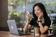 © Heng Yu/Stocksy - Woman at cafe using cellphone.