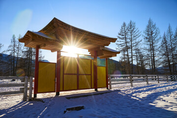 Wall Mural - Wooden gate to a Buddhist temple in winter on the street