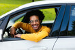 © BONNINSTUDIO/Stocksy - Cheerful mixed race driver peeking from car window