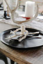 DIY Mummy Holds Cutlery On Plate On Halloween Decorated Table