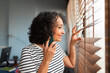 © Lightsy/Stocksy - Businesswoman on the phone while she is looking through the window