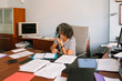 © Lightsy/Stocksy - Woman surrounded by documents in the office