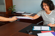© Lightsy/Stocksy - Smiley lawyer receiving files