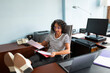 © Lightsy/Stocksy - Woman reviews documents in the office