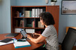 © Lightsy/Stocksy - Woman using a tablet for working in the office