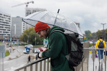 Man Under An Umbrella Near The Railing