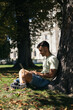 © Pedro Merino/Stocksy - Young man working and studying with laptop outdoors