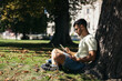 © Pedro Merino/Stocksy - Young woman using laptop and smartphone outdoors
