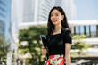 © Heng Yu/Stocksy - Asian office lady standing in the CBD of the City