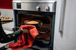 © Daniel Gonzalez/Stocksy - Crop girl taking out hot cake from oven