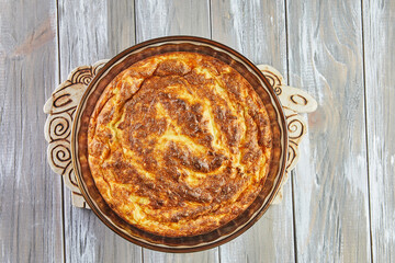 Wall Mural - Puffed cauliflower souffle in transparent bowl on wooden background