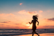 Woman Silhouette Running On The Beach