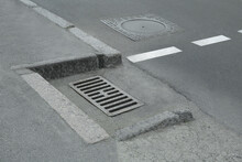 Metal Drain Grate And Sewer Hatch On Asphalt Outdoors