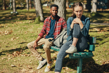 Angry, fight and interracial couple in conflict in a park with stress about divorce, mental health and marriage fail. Depression, sad and black man and woman frustrated with a problem in nature