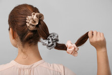 Woman With Silk Scrunchies On Ponytail Against Grey Background
