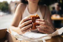 Unrecognizable Woman Eating A Hamburger Outdoors