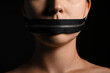 Young woman with zipper on her mouth against dark background, closeup. Censorship concept