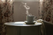 © Pixel Stories/Stocksy - Detail shot - coffee mug on table with steam rising above
