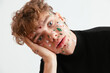© BONNINSTUDIO/Stocksy - Bored young male with Christmas stickers on face