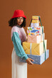 © BONNINSTUDIO/Stocksy - Black female with stack of wrapped gifts