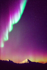 Wall Mural - snow mountains with background of milky way , huge aurora hanging in the clean dark purple night sky