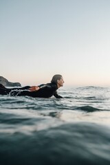 Female surfer surfing with a longboard at the Cordoama Beach on a sunny day in Algarve, Portugal