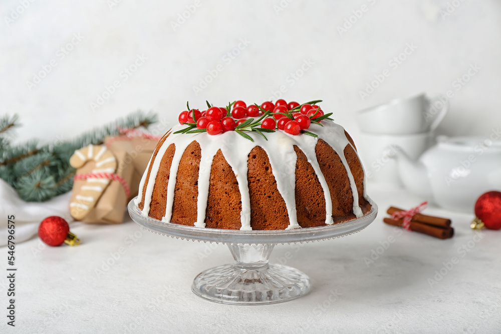 Dessert stand with traditional Christmas cake on light background