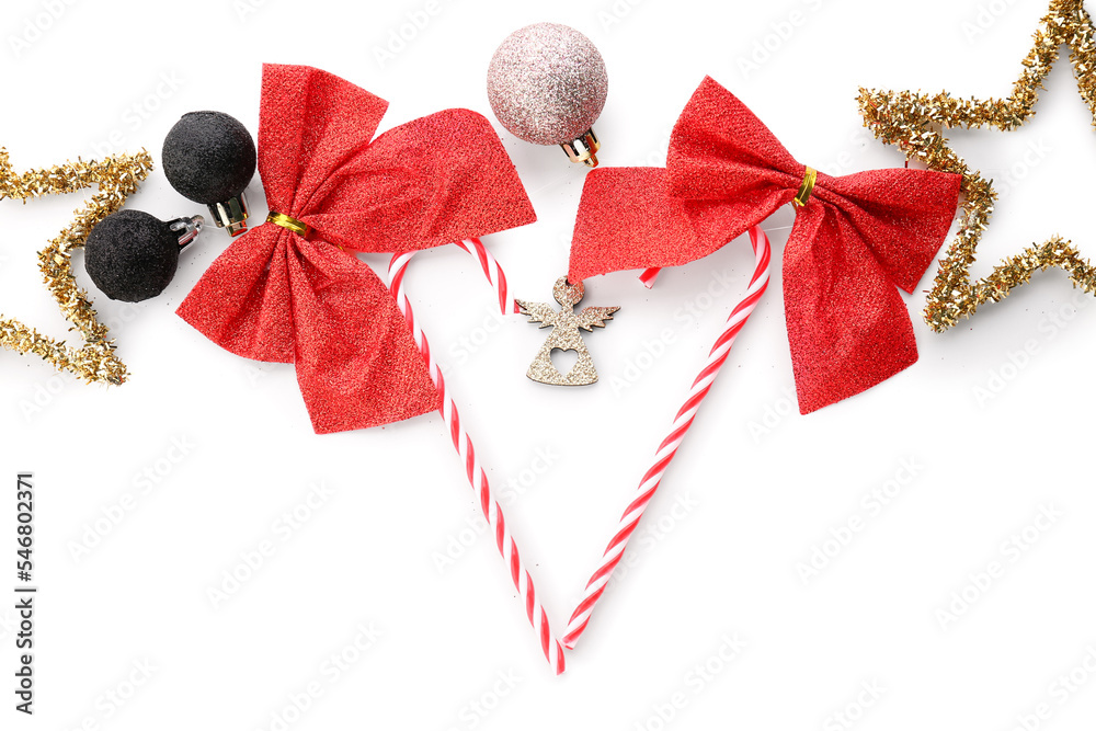 Composition with sweet candy canes and Christmas decorations on white background