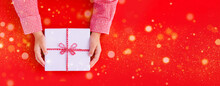 Gift Box In Children's Hands On A Red Background, Presenting A Gift	
