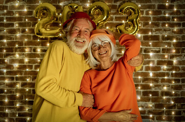 Wall Mural - Celebrate event new year for couple of nice people - beautiful senior adult man and woman celebrate holiday by night. Happiness lifestyle for mature retired people, party lights