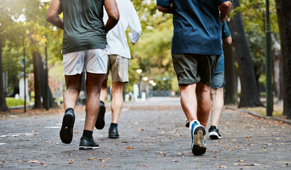 Poster - Fitness, men and running club in park, cropped legs in nature for exercise on garden path together. Motivation, workout and friendship, group of senior friends run, health and wellness in retirement.