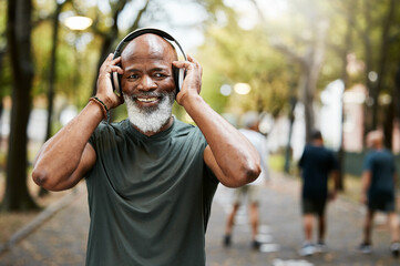 Fitness, headphone and senior black man, music and exercise in nature park, portrait and running for health and wellness. Elderly runner, streaming and podcast while training, workout and run outdoor