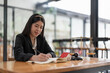 © Natee Meepian - Portrait confidence asian lawyer taking note sitting at work desk in office. real estate concept.