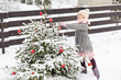 Girl playing near the decorated Christmas tree