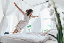 Woman Jumps On The Bed As If In Flight
