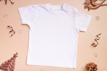 Wall Mural - Baby t-shirt mockup for logo, text or design on beige background with winter decorations top view