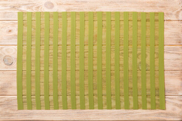 Wall Mural - Top view of green tablecloth for food on wooden background. Empty space for your design