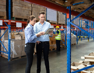 distribution warehouse manager and client businesswoman using digital tablet checking inventory stor