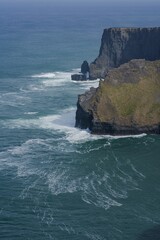 Poster - Vertical shot of high cliffs on the shore of the sea during stormy weather