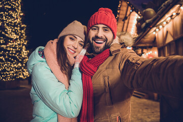 Poster - Photo of positive pretty girlfriend boyfriend tacking selfie cuddling walking outdoors urban city market