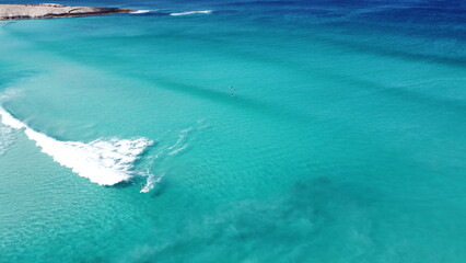 Wall Mural - Drone footage of surfers waiting for waves in Esperance Australia. Amazing blue clear water. 2 surfers on surfboards in the ocean. Foamy wave in the front.