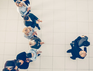 Wall Mural - top view. business partners standing in front of a large group of employees.