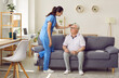 © Studio Romantic - Friendly young female nurse combs hair of older man sitting on sofa in nursing home. Caregiver cares for elderly man in specialized institution for pensioners. Nursing and elderly care concept.