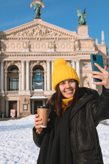 Poster - woman traveler drinking coffee to go taking selfie in front of opera building