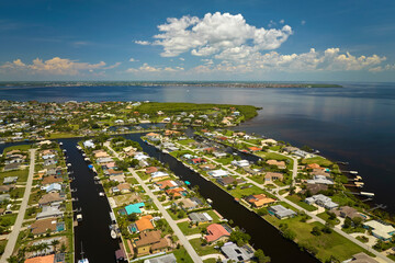 Wall Mural - Aerial view of residential suburbs with private homes located on gulf coast near wildlife wetlands with green vegetation on sea shore. Living close to nature concept