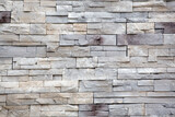 Fototapeta  - Rows of gray and white cut stone blocks for an exterior wall.