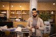 © Caia Image - Portrait confident young male designer with coffee and phone