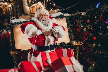 Wall Mural - Photo of good personage santa sitting sleigh pulled by reindeer holding rope enjoying travel streets of city carrying miracle outside