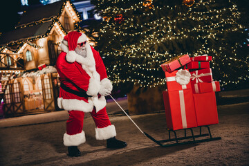 Wall Mural - Full length photo of retired old man hold sled giftbox walk snowy street travel another city wear x-mas costume coat sunglass hat outside