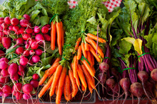 Fresh Carrots, Beets, And Radishes On Display In A Farmers Market.